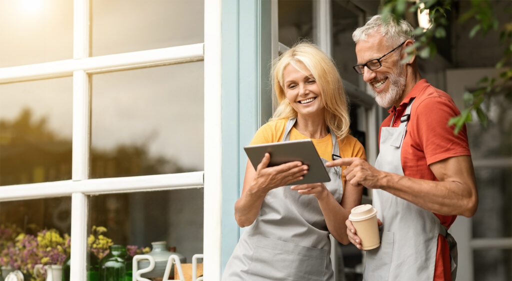 Mature smiling couple outside small business