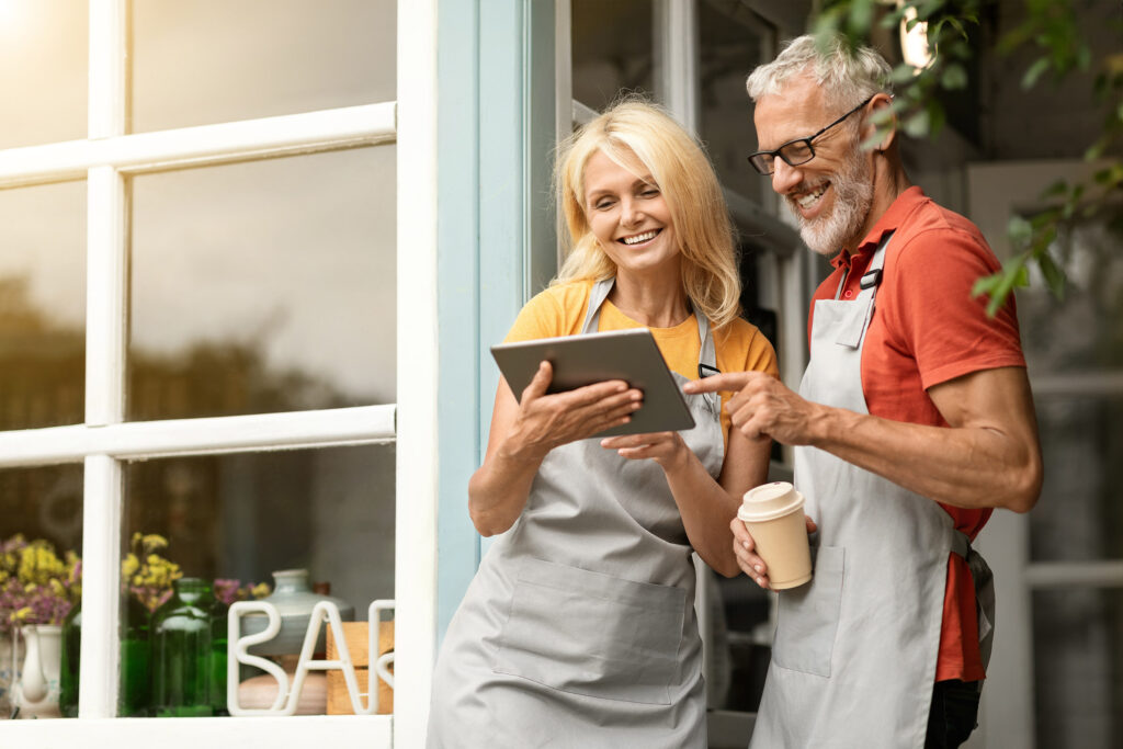 Mature smiling couple outside small business